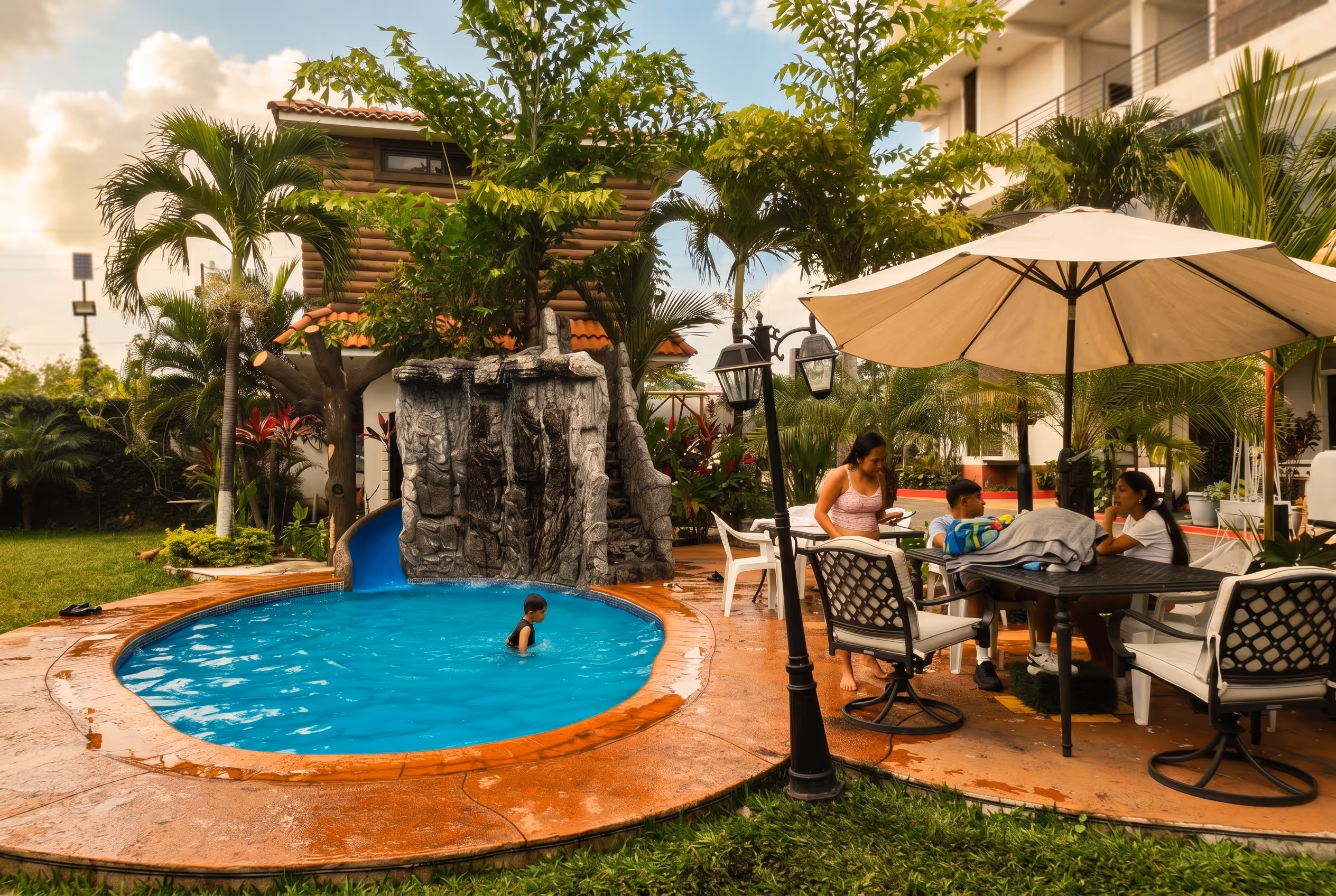 Chapoteadero con cascada de roca junto a área de comedor exterior en Hotel Malibu